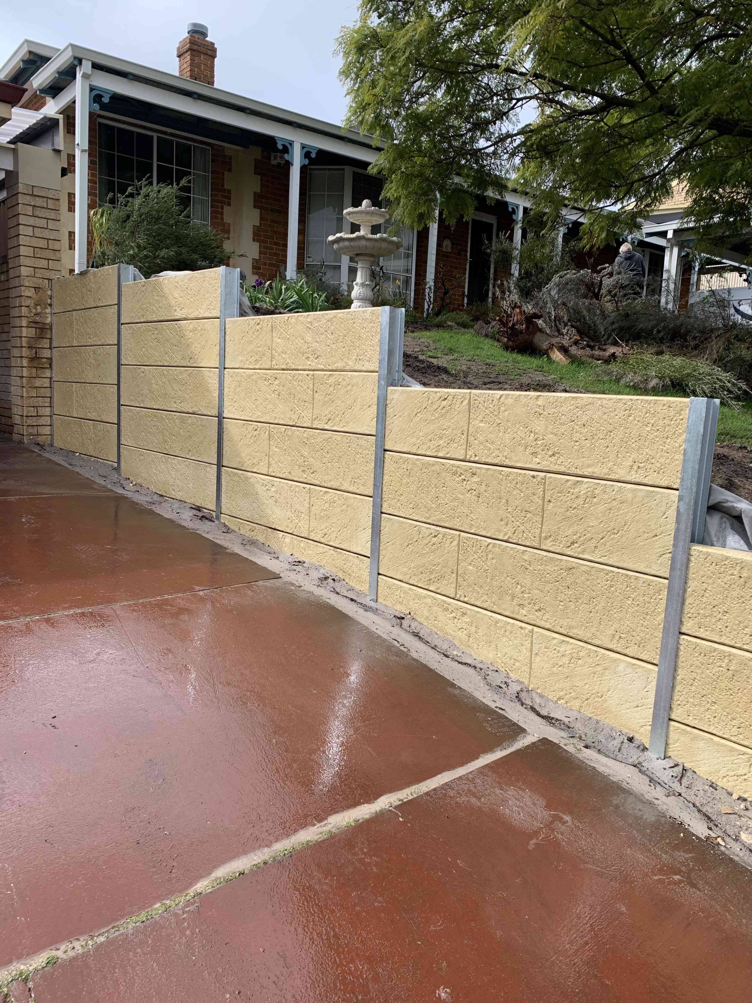 Stepped limestone retaining wall beside a Perth driveway